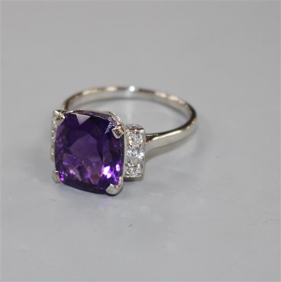 A white metal, amethyst and six stone diamond set dress ring, size R/S, gross weight 6.2 grams.